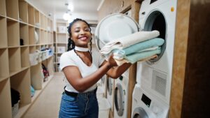 woman folds laundry in boston laundromat